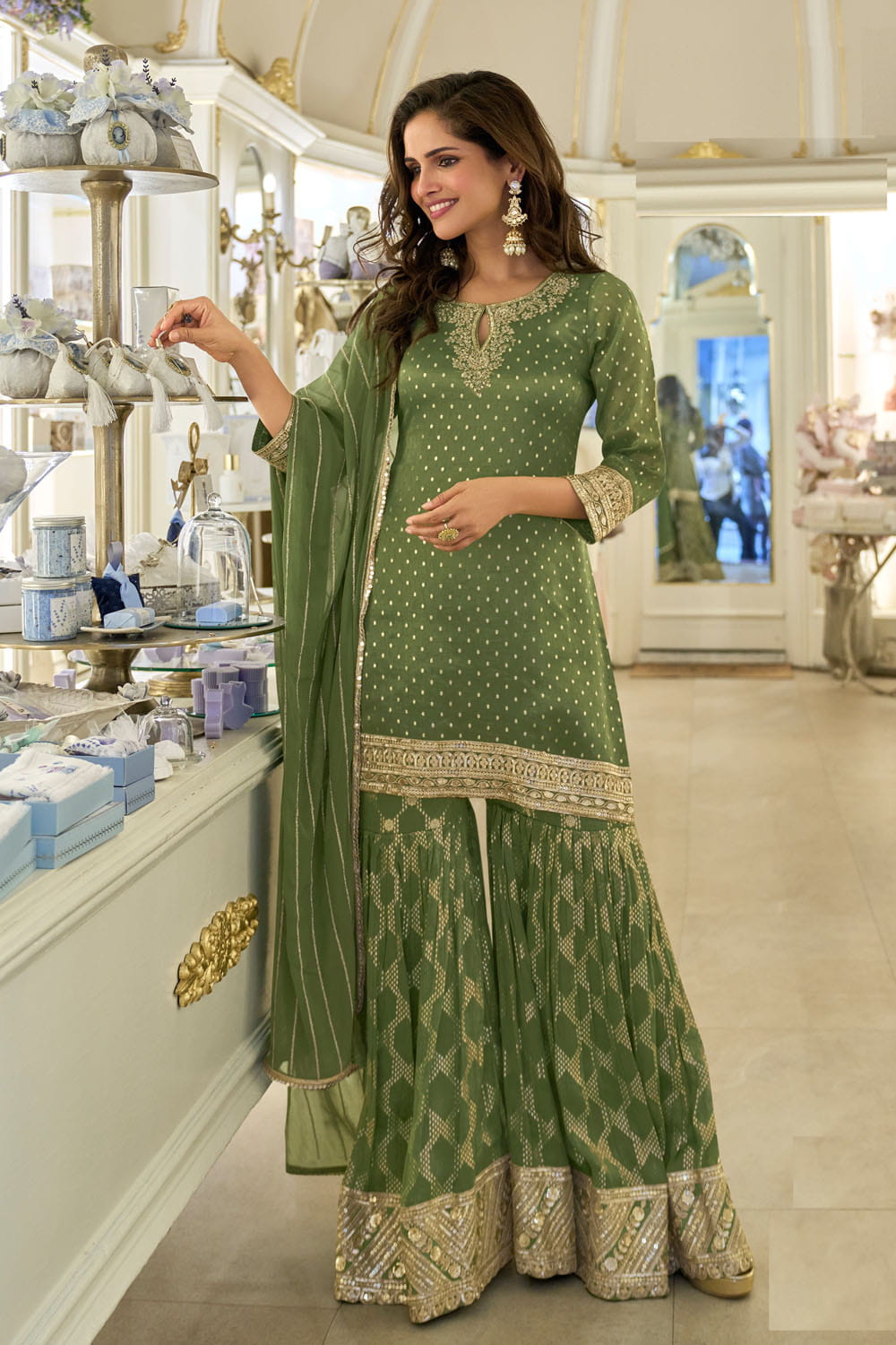 Woman in a green traditional outfit standing in a store.