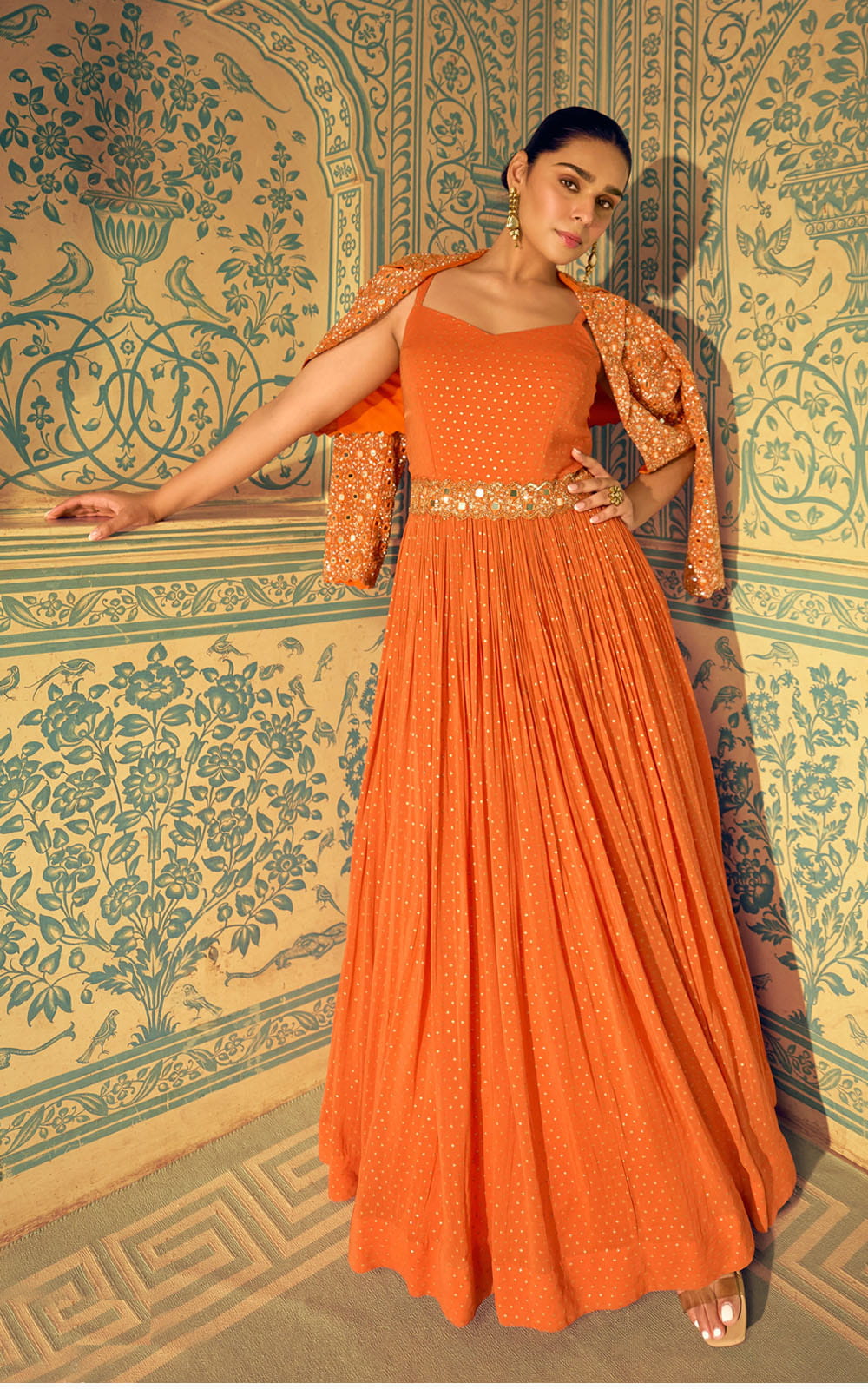 Woman in an orange dress with a patterned background