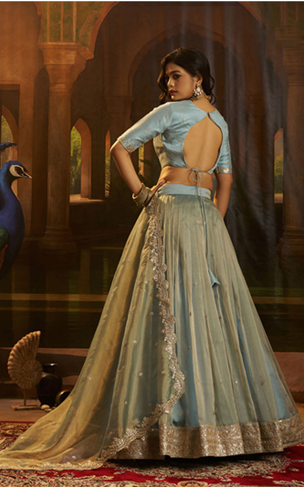 Woman in a traditional outfit with a peacock in an ornate setting