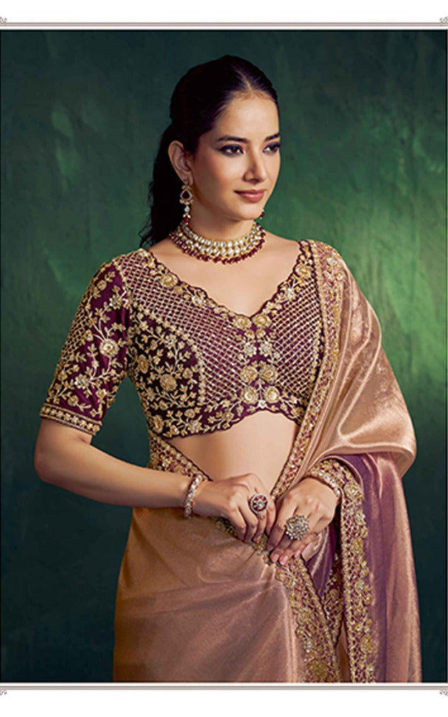 Woman in traditional attire with jewelry against a green background