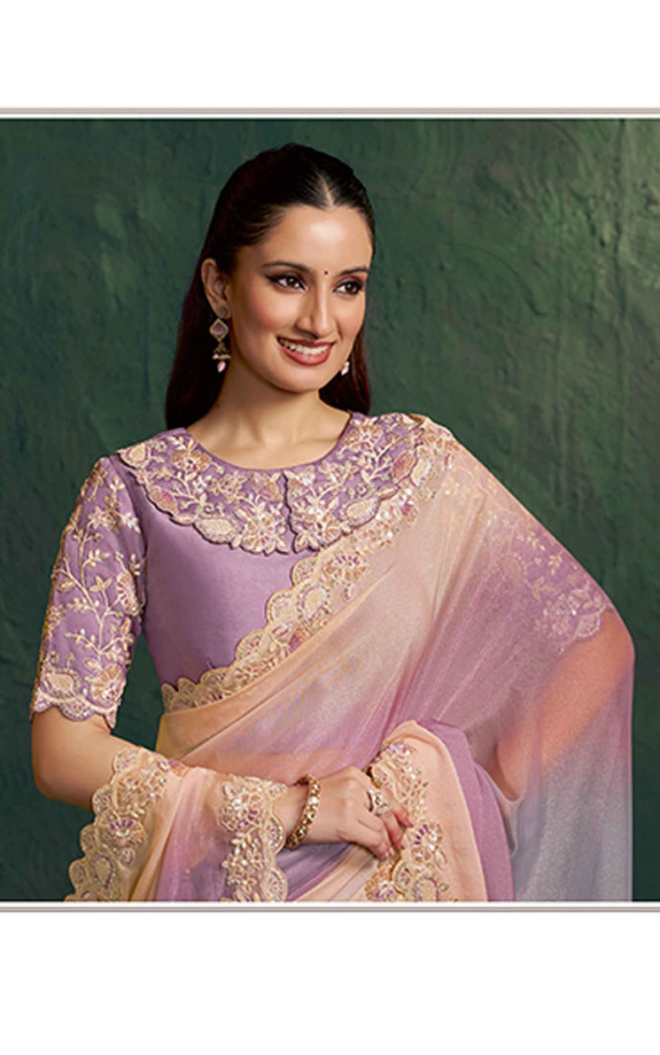 Woman wearing a traditional embroidered saree with a green background