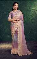 Woman wearing a purple and beige saree with a green background