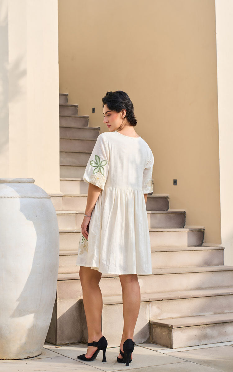 Woman in a white dress standing on stone steps outdoors