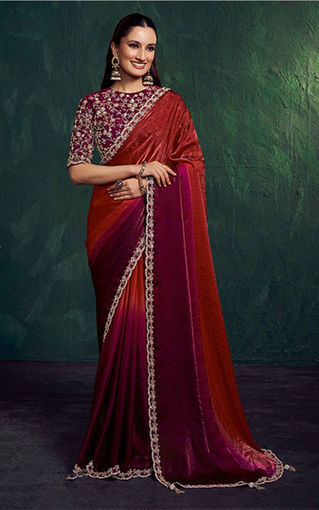 Woman wearing a red and pink saree with a green background
