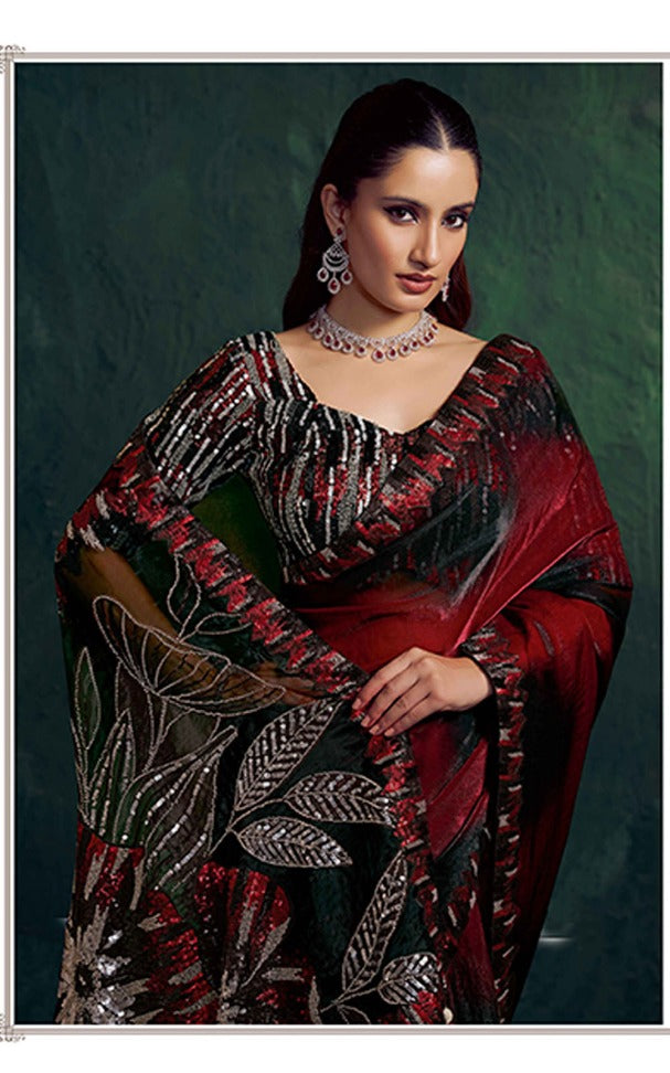 Woman wearing a red and black saree with intricate patterns on a dark background