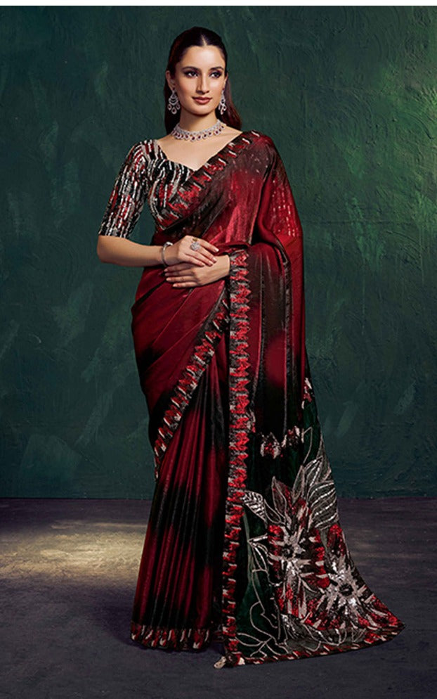 Woman wearing a maroon saree with intricate designs against a dark background