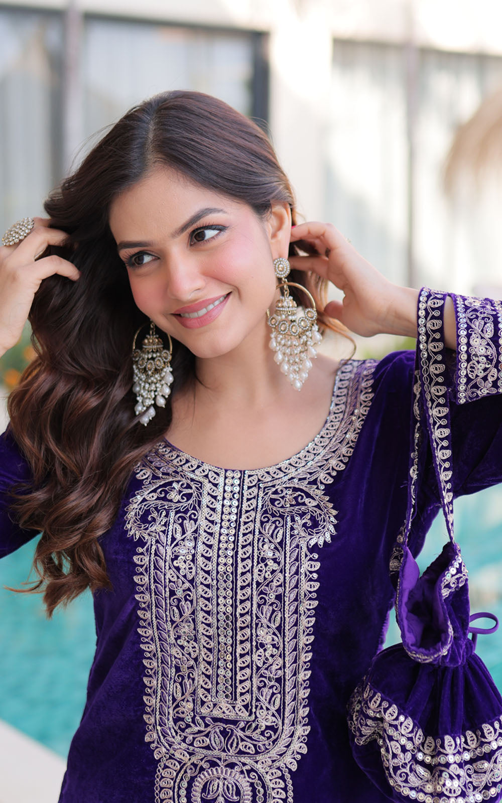 Woman wearing a purple embroidered outfit with a blurred background