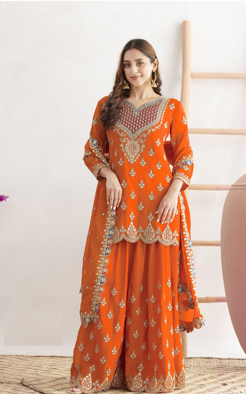 Woman wearing an orange embroidered traditional outfit on a white background