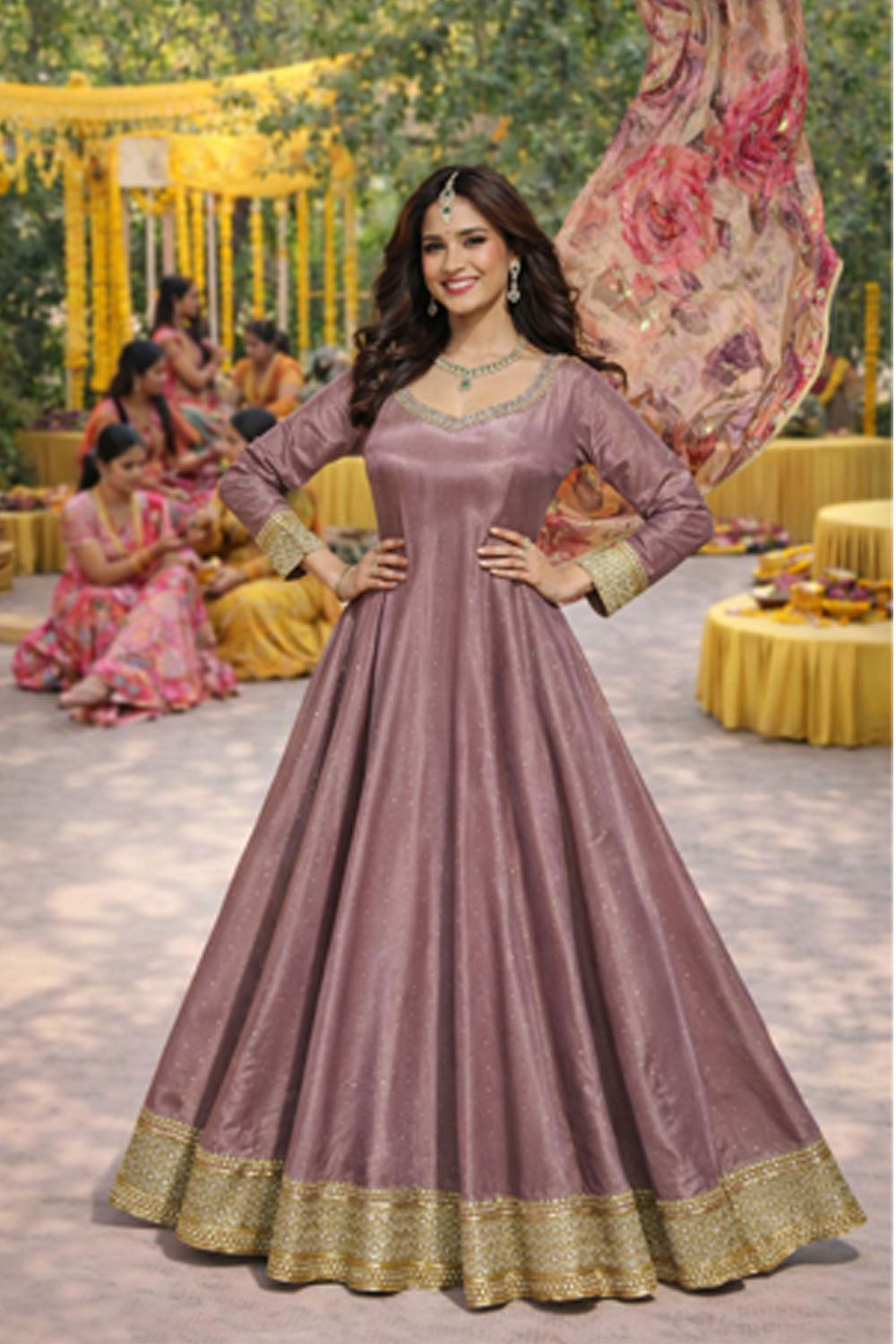 Woman in a purple anarkali suit with gold border at a festive outdoor event.