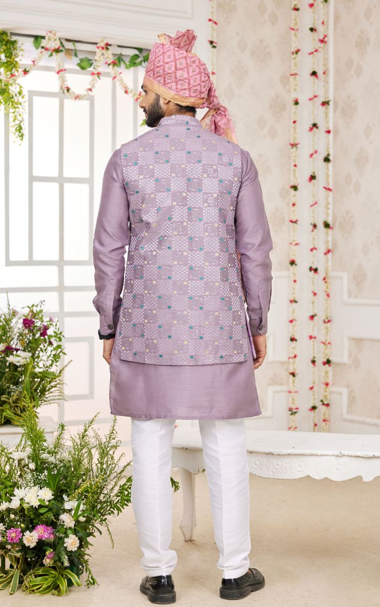 Man wearing a light purple sherwani with white pants in a decorated room.