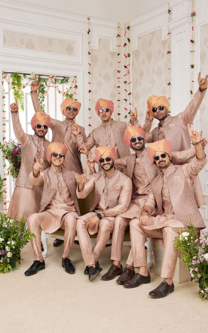 Group of men in matching outfits with turbans in a decorated room.