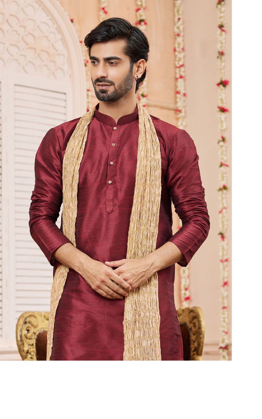 Man wearing a maroon kurta with a beige shawl in an indoor setting